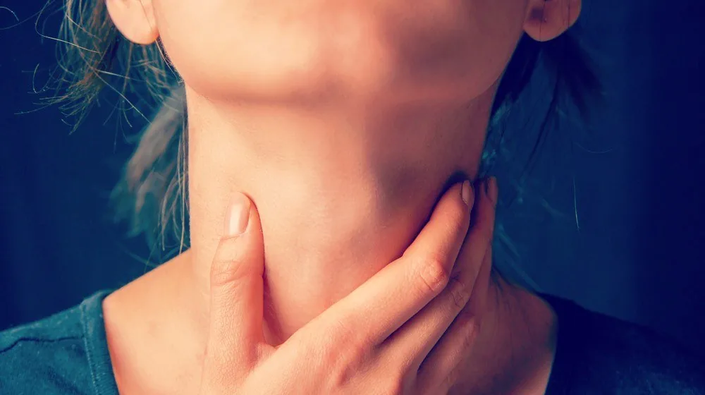 unrecognizable-woman-holds-her-throat-sore-throat-problems-ss-FEATURE-